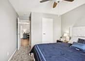 Thumbnail 14 of 24 - A bedroom with a bed, nightstand, and a ceiling fan.