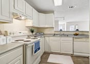 Thumbnail 4 of 17 - A kitchen with white cabinets and a white refrigerator.