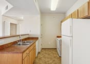 Thumbnail 9 of 36 - A kitchen with a white refrigerator and brown countertops.