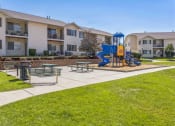 Thumbnail 13 of 18 - our apartments have a playground with a blue slide and picnic tables