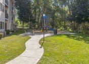 Thumbnail 14 of 18 - a sidewalk leading to a swing set in a park