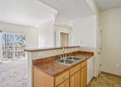Thumbnail 8 of 36 - A kitchen with a brown counter top and white cabinets.