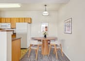 Thumbnail 7 of 36 - A dining room with a table and chairs.