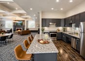 Thumbnail 2 of 20 - Open concept kitchen and living area with island seating at The Ellison Apartments, Layton, Utah