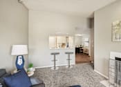 Thumbnail 4 of 24 - A living room with a grey couch and a blue lamp.