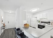 Thumbnail 5 of 20 - A kitchen with a bowl of fruit on the island.