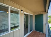 Thumbnail 30 of 32 - a covered porch with sliding glass doors and a deck