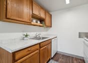 Thumbnail 5 of 32 - an empty kitchen with wooden cabinets and a sink