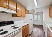 Thumbnail 1 of 32 - an empty kitchen with white appliances and wooden cabinets