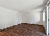 Thumbnail 8 of 32 - an empty living room with wood flooring and white walls