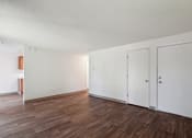 Thumbnail 15 of 32 - an empty living room with white walls and wood floors