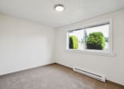 Thumbnail 11 of 32 - an empty bedroom with a large window and carpeting