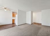 Thumbnail 16 of 32 - an empty living room with white walls and wood flooring