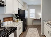 Thumbnail 12 of 13 - A kitchen with a black stove top oven and white cabinets at Arbors at Hickory Creek Apartments , University Park, Illinois