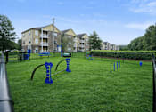 Thumbnail 21 of 25 - A playground with blue equipment is in front of apartment buildings.