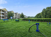 Thumbnail 20 of 25 - A playground with a blue slide and a green lawn.