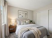 Thumbnail 17 of 21 - A bedroom with a large bed and a painting on the wall.