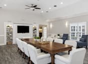 Thumbnail 2 of 22 - A dining room with a wooden table and white chairs.