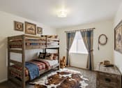 Thumbnail 21 of 22 - A room with a bunk bed, a desk, and a cowhide rug.