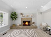 Thumbnail 13 of 22 - A living room with a fireplace and a tree.