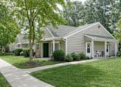 Thumbnail 3 of 4 - A house with a green lawn and a tree in front.