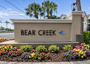Thumbnail 1 of 17 - A sign that says Bear Creek stands in front of some buildings.