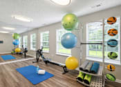 Thumbnail 8 of 23 - A gym with exercise balls and mats.