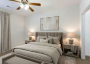 Thumbnail 25 of 25 - A bedroom with a large bed and a ceiling fan.