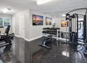 Thumbnail 5 of 13 - A spacious gym with a variety of equipment including treadmills, weights, and a squat rack.