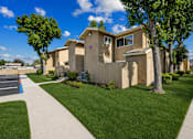 Thumbnail 3 of 21 - A row of houses with a sidewalk in front.