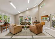 Thumbnail 9 of 21 - A living room with a brown couch and a coffee table.