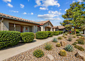 Thumbnail 5 of 13 - A house with a red tile roof and a well-maintained garden in front.