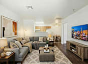 Thumbnail 10 of 13 - A living room with a grey sofa and a wooden coffee table.
