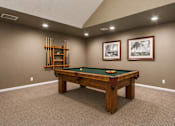 Thumbnail 5 of 7 - A pool table in a room with a wooden frame and a green felt cloth.