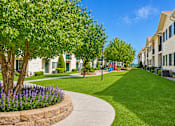 Thumbnail 3 of 22 - A residential area with a sidewalk and a grassy area.