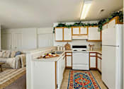 Thumbnail 15 of 22 - A kitchen with white appliances and wooden cabinets.