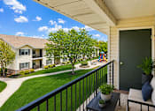 Thumbnail 12 of 22 - A balcony with a black railing and a green door.