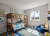 Thumbnail 15 of 21 - A room with two bunk beds and a blue bean bag chair.