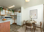 Thumbnail 16 of 22 - A kitchen with a dining table set for four.