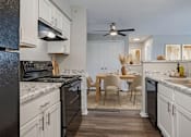 Thumbnail 10 of 13 - A kitchen with a table and chairs in the middle of it. at Arbors at Hickory Creek Apartments , University Park, IL, 60484