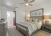 Thumbnail 11 of 16 - A bedroom with a bed, nightstand, and a ceiling fan.