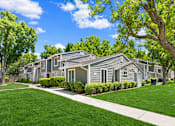 Thumbnail 1 of 16 - A row of houses with green trees in front.