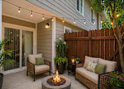 Thumbnail 15 of 16 - A patio with a fire pit and seating area.