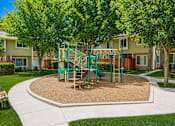 Thumbnail 6 of 16 - A playground with a green slide and a brown sandbox.