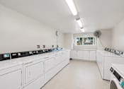 Thumbnail 10 of 21 - A row of washing machines in a laundromat.