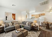 Thumbnail 9 of 13 - A living room with a grey couch, a coffee table, and a painting on the wall.