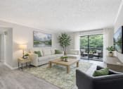 Thumbnail 9 of 19 - A living room with a couch, a coffee table, and a painting on the wall.
