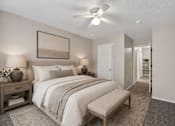 Thumbnail 9 of 14 - A bedroom with a large bed and a ceiling fan.