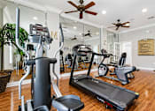 Thumbnail 9 of 24 - A well-equipped home gym with a variety of exercise machines.