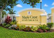 Thumbnail 24 of 24 - A sign for Maple Crest Apartments is displayed in front of a white fence.